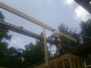 Carpenter setting a ridge beam over a new addition frame — Ice Dam Removal by Roofing Brothers in Rudolph
