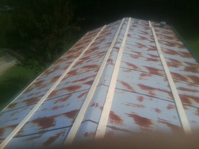 Rusted metal roof panels with new wood purlins before replacement — Storm Damage Roof Repair in Rudolph by Roofing Brothers
