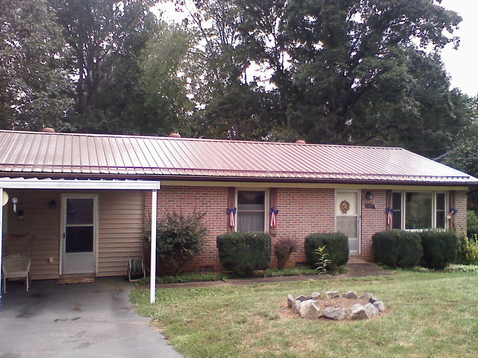 Bronze metal roof and carport on a brick ranch home — Roof Repair work by our crew in Rudolph