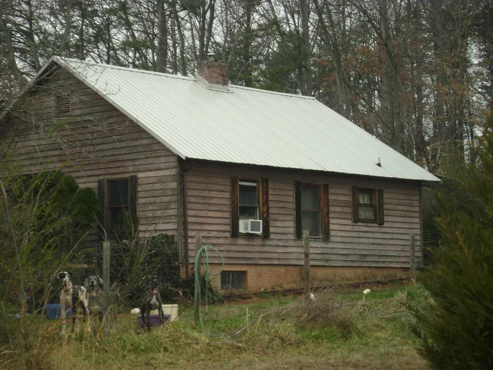White metal roof on an old wood sided farmhouse, from a Metal Roof Installation job in Rudolph